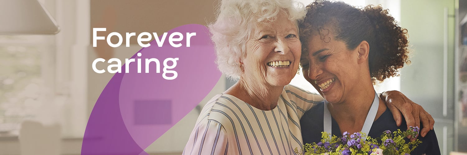 Tow women smiling and hugging