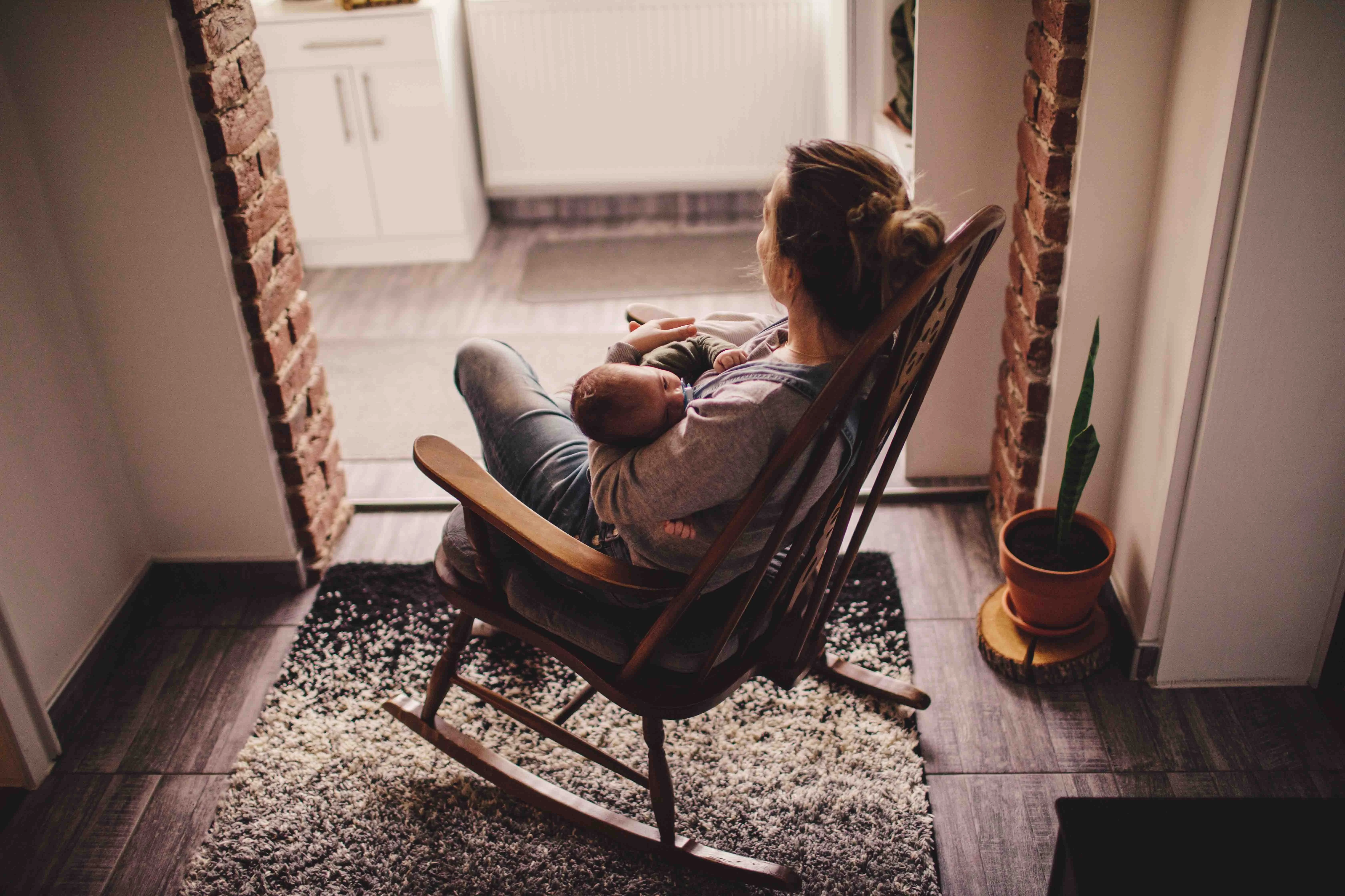a person sitting in a chair holding a baby
