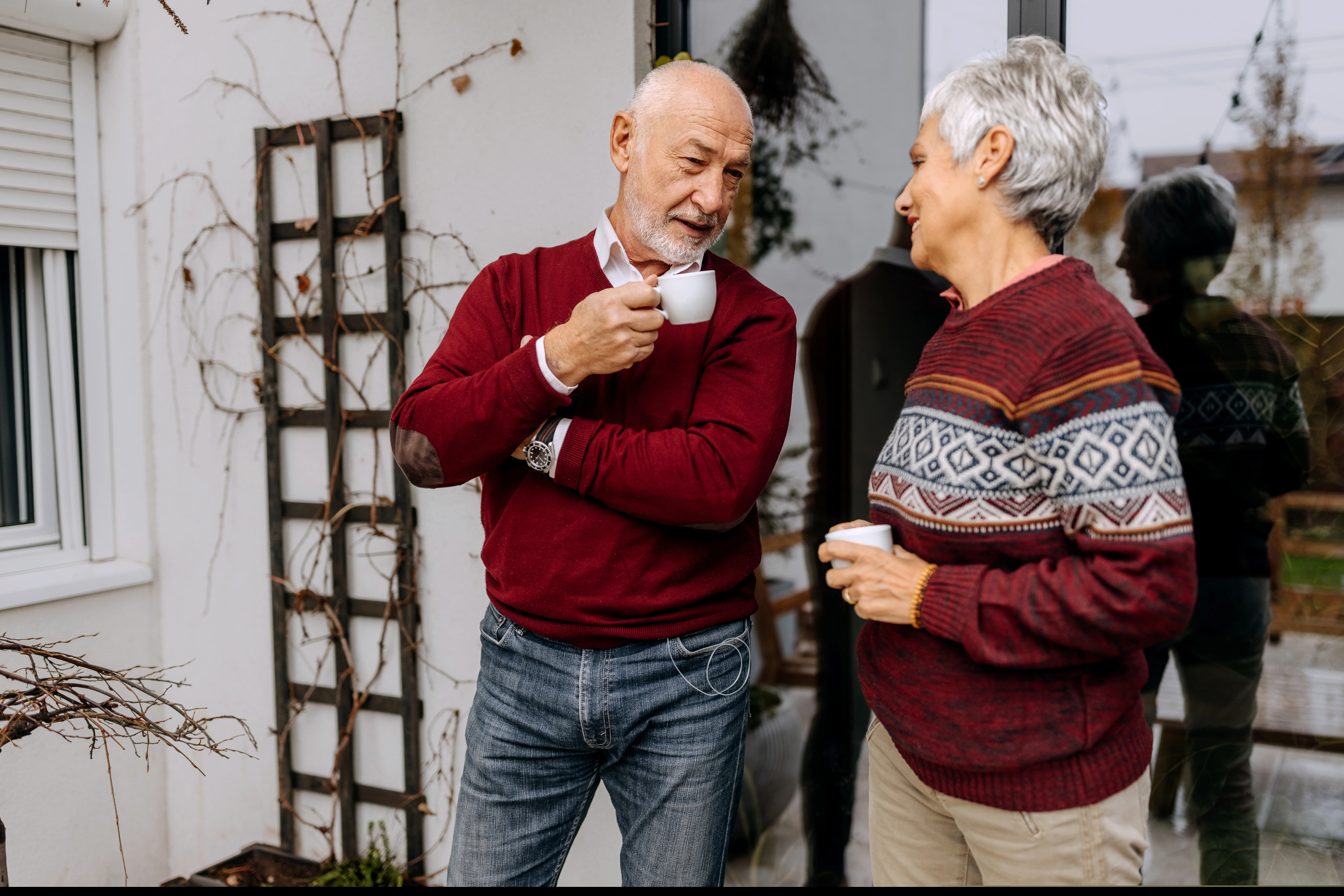 A man and a woman holding cups while talking