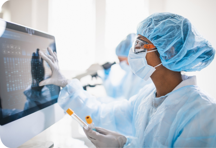 Eine Person in einem Laborkittel und einer Maske mit einem Computer